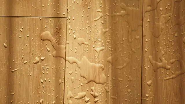 Water droplets on a wood floor surface after a leak