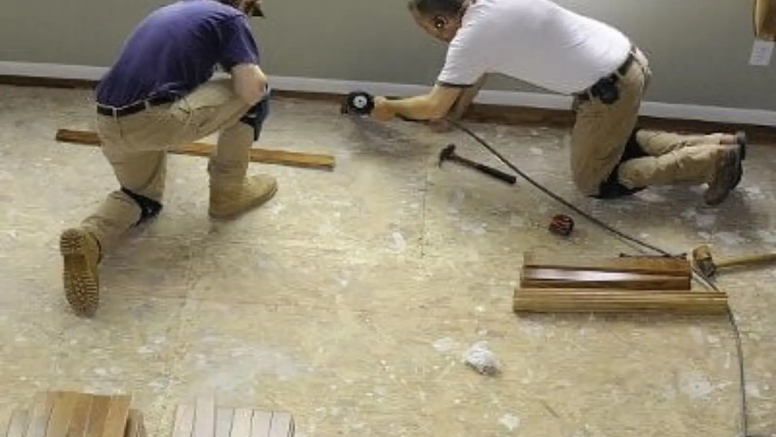Workers repairing a water-damaged floor during water damage repair
